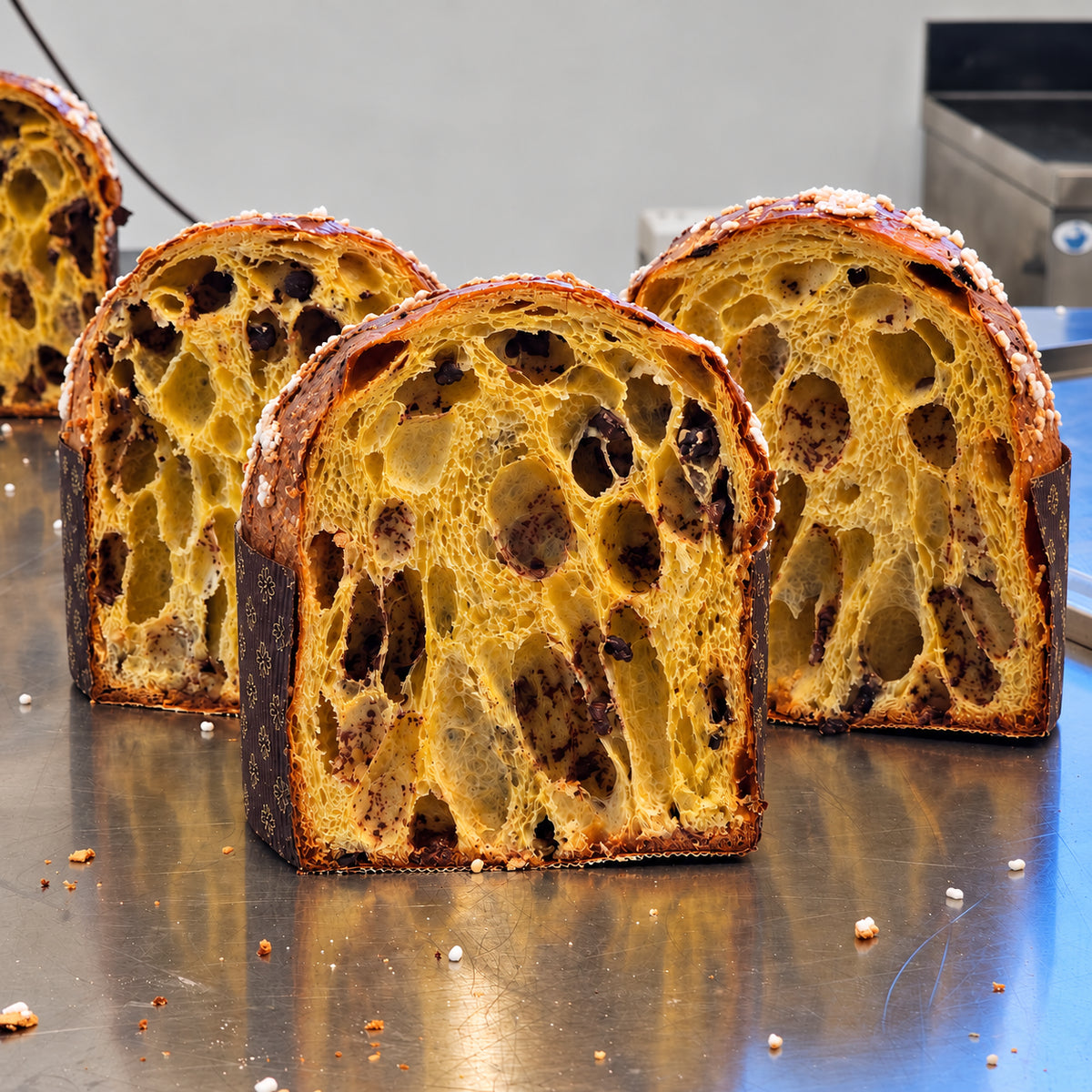 Panettoni artigianali aperti sul banco del laboratorio SicilyAddict, dettaglio dell’impasto e del cioccolato